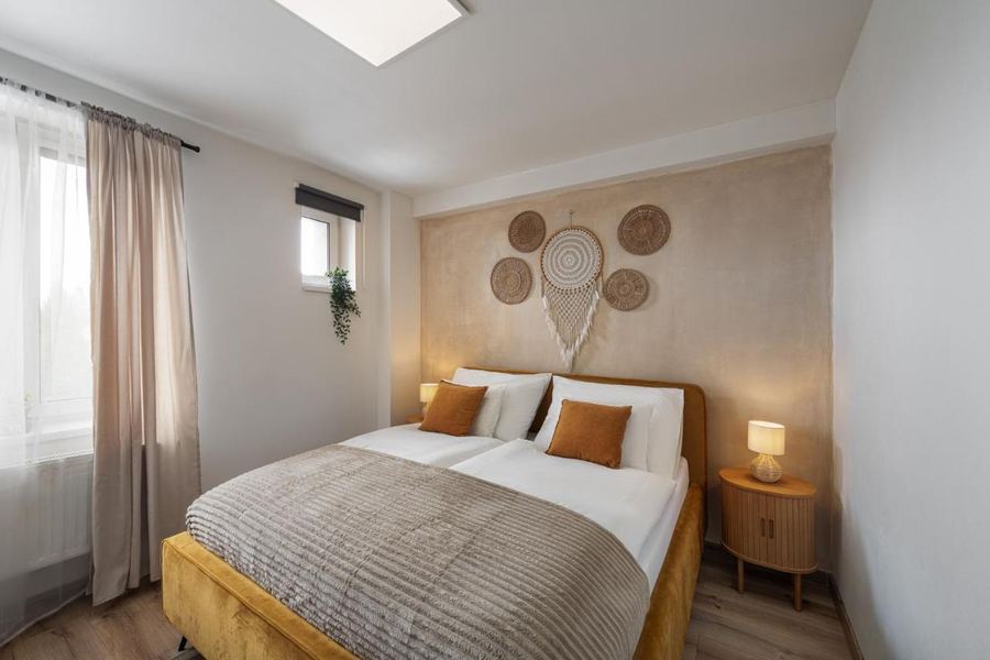 Bedroom with double bed, bedside lamps and warm textured wall